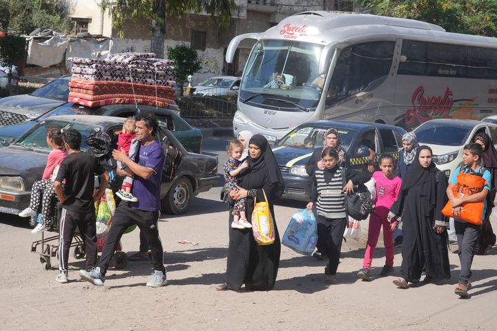 Palestinians flee to the southern Gaza Strip after the Israeli army issued an evacuation warning to a population of over 1 million in northern Gaza and Gaza City to seek refuge in the south ahead of a possible Israeli ground invasion, Friday, Oct. 13, 2023. (AP Photo/Hatem Moussa)