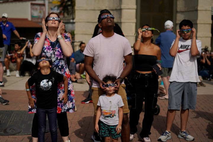 Viewers use special glasses to watch as the moon moves in front of the sun during an annular solar eclipse, or ring of fire, Saturday, Oct. 14, 2023, from San Antonio. (AP Photo/Eric Gay)