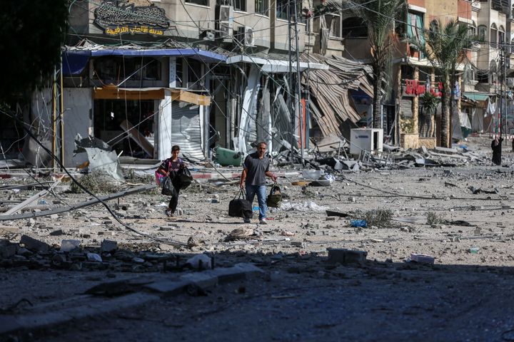 People walking amidst the destruction of houses and streets in Khan Yunis, located in the southern Gaza Strip, amid the devastation caused by Israeli airstrikes. (Photo by MOHAMED ZAANOUN/Middle East Images/AFP via Getty Images)
